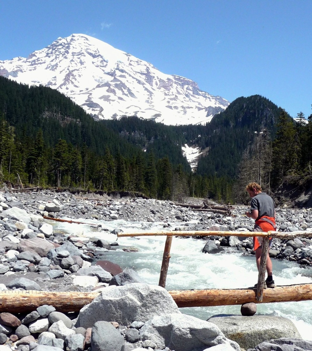 A hiker crosses the Nisqually on the bridge near Cougar Rock.