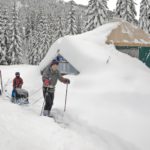A happy family skis from the Mount Tahoma Trails yurt after a snow-filled adventure.