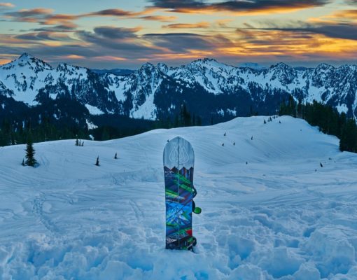 Backcountry sunset with snowboard on the snow