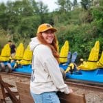 Woman standing by a bench with railcycles in the background
